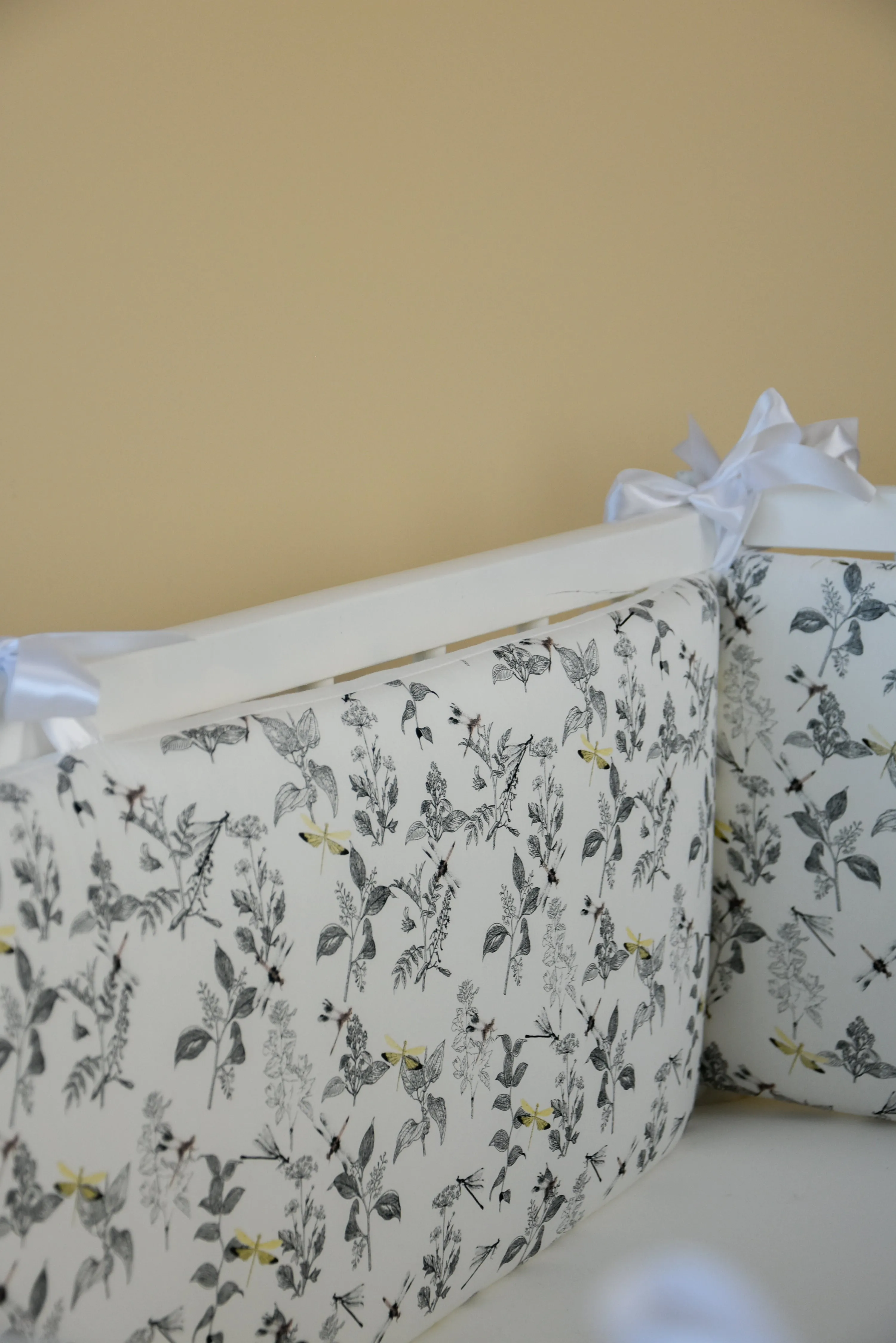 White crib bumper with with leaves and yellow wedges