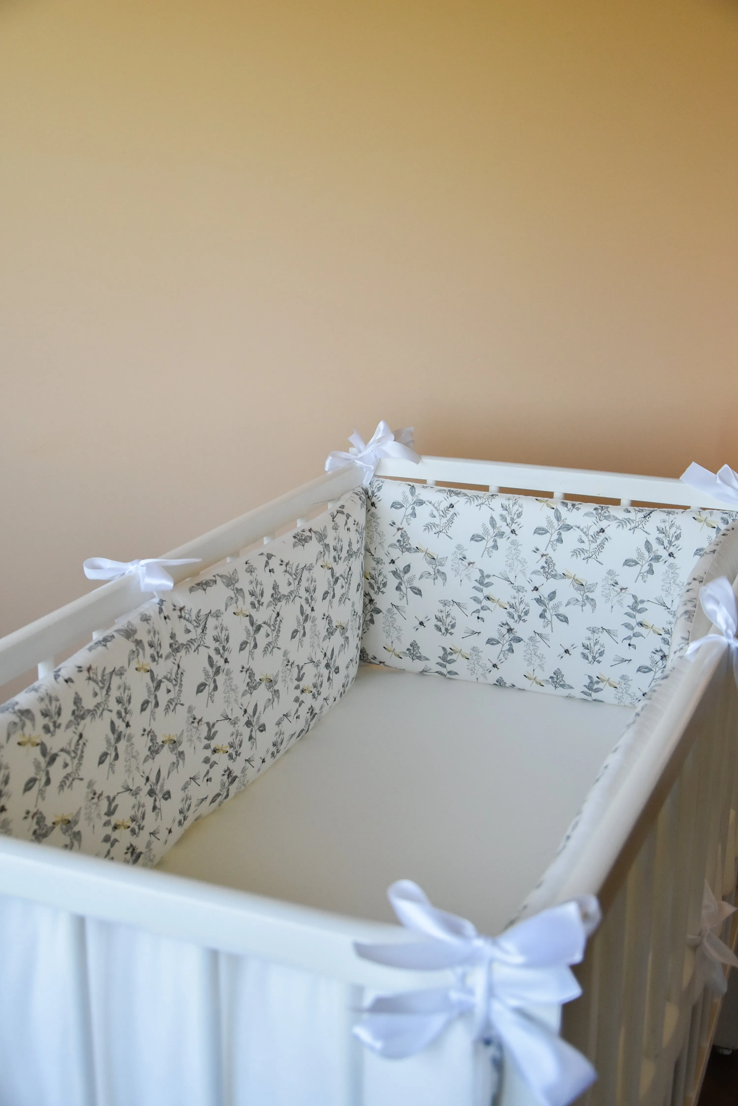 White crib bumper with with leaves and yellow wedges